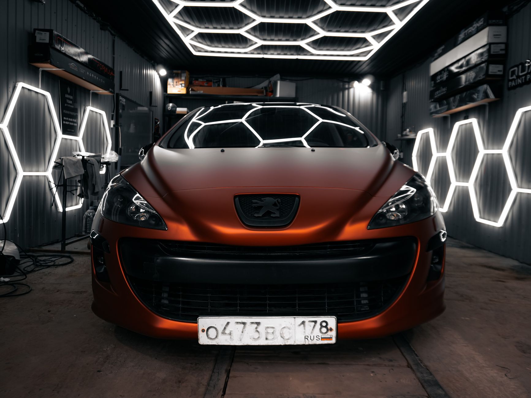 Hala studia AutoDetailia, auto na stanowisku w świetle LED